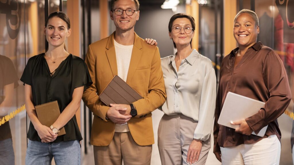 About us page: team of four people smiling in an office hallway