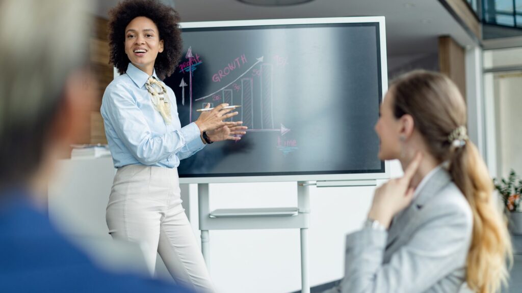 Case de sucesso: profissional apresenta um gráfico de crescimento para colegas numa reunião