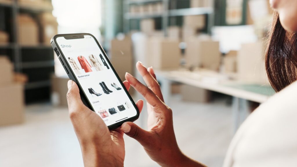 GEO ecommerce: mãos usando um aplicativo de compras de calçados no celular