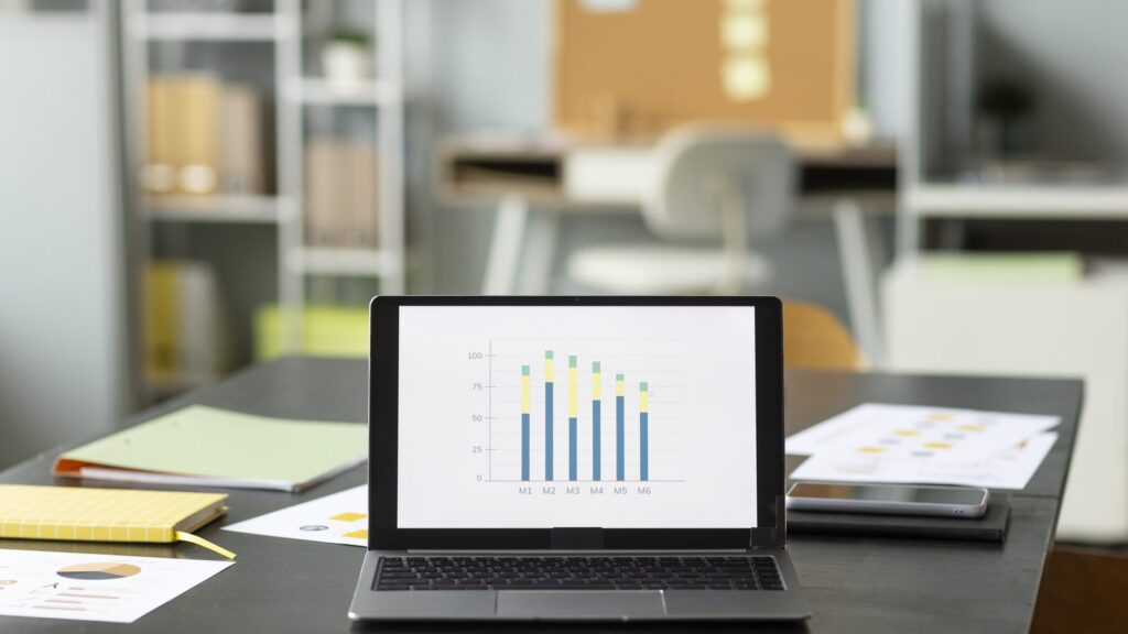 Search Console AI: notebook com um relatório em gráfico de barras sobre uma mesa de escritório