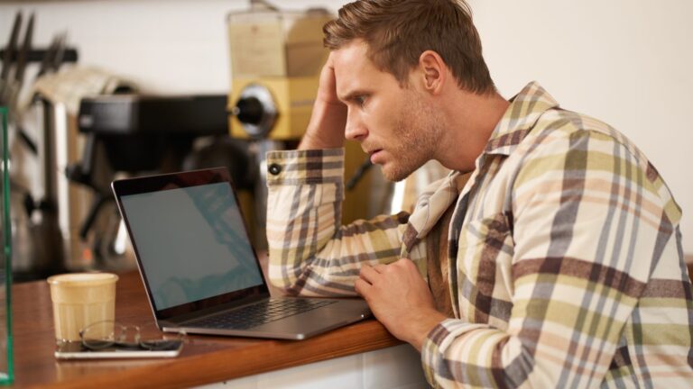 Website not showing up on Google: worried man looking at a laptop screen trying to understand a problem